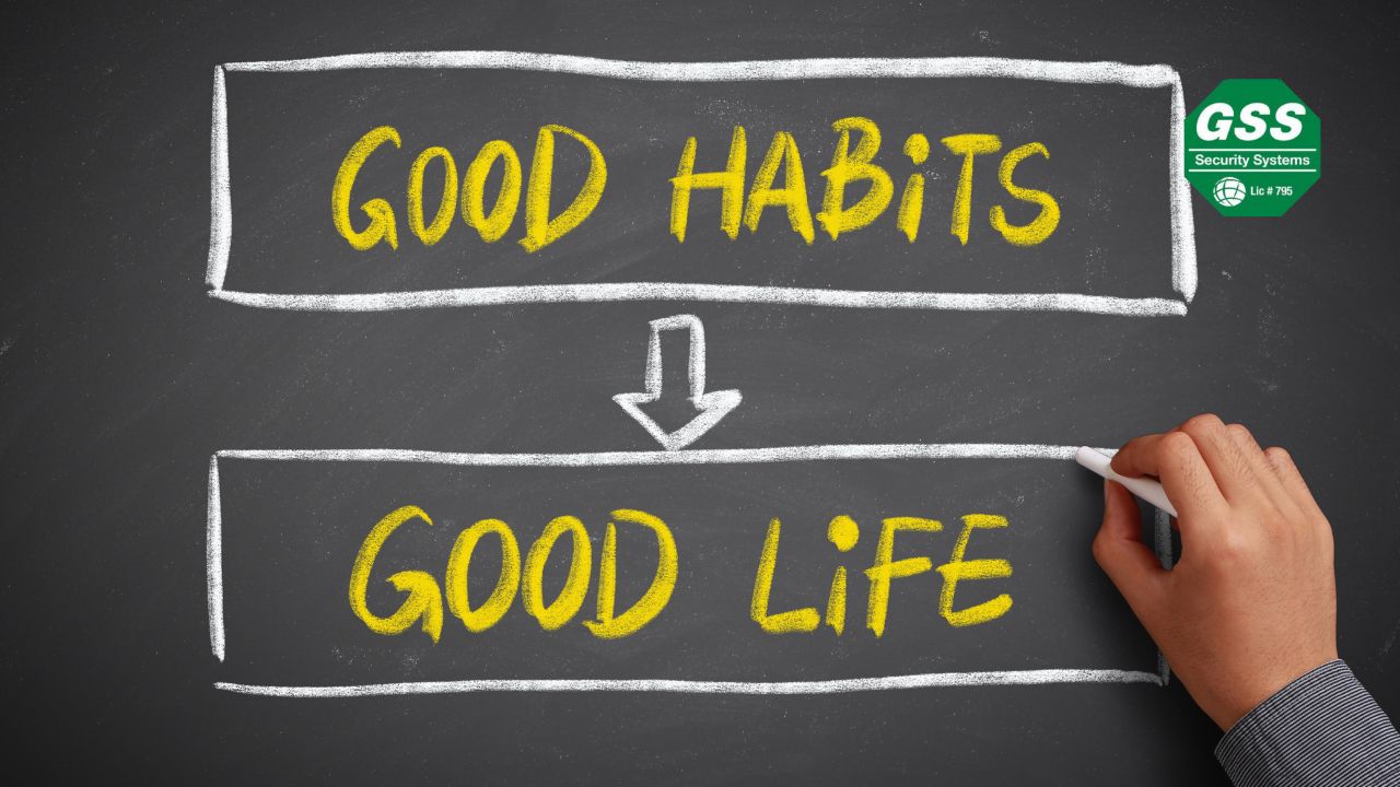 A hand writing on a blackboard with the words “GOOD HABITS” leading to “GOOD LIFE” in yellow chalk, symbolizing the importance of positive routines. The "GSS Security Systems" logo is displayed in the top right corner.